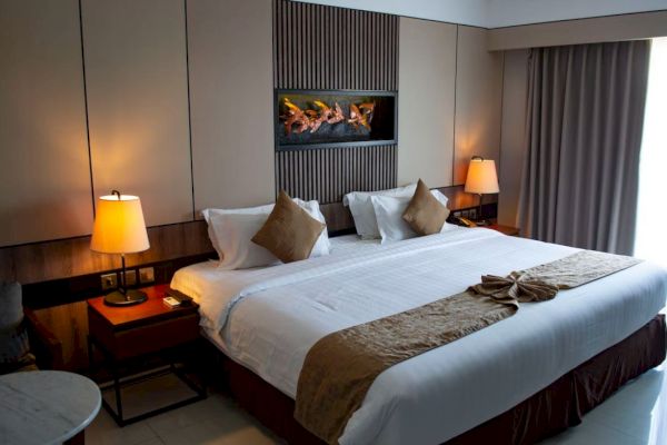 A cozy hotel room with a large bed, stylish lamps, and elegant decor.