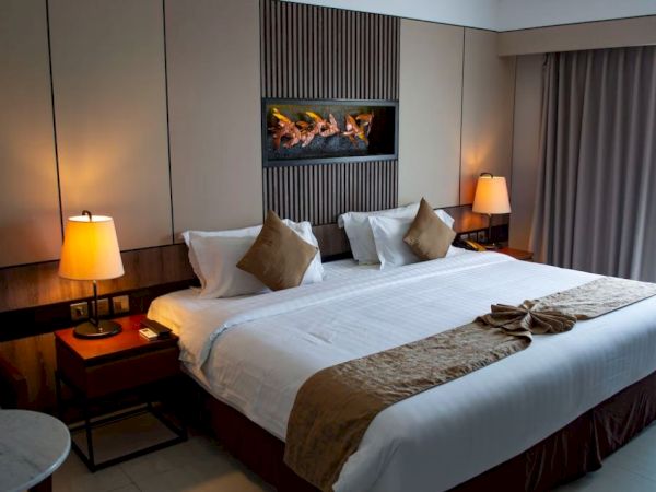 A cozy hotel room with a large bed, stylish lamps, and elegant decor.